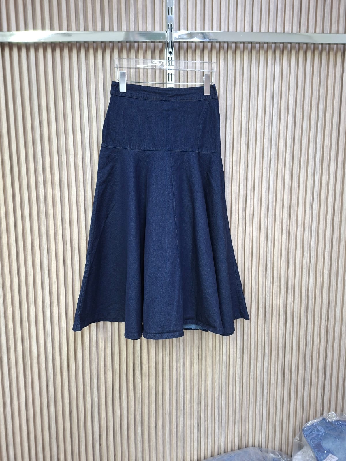 Falda Denim Arya. Este Es Un Modelo Que Ofrece Un Look Elegante Pero Casual, De Corte A, Con Un Movimiento Fluido Al Caminar Y De Silueta Favorecedora, El Largo Es Midi, Llegando Aproximadamente A Media Pantorrilla, Lo Que La Hace Sofisticada Y Versátil.